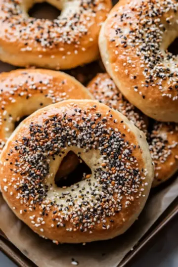 High protein bagels with everything seasoning on a parchment paper cooling rack