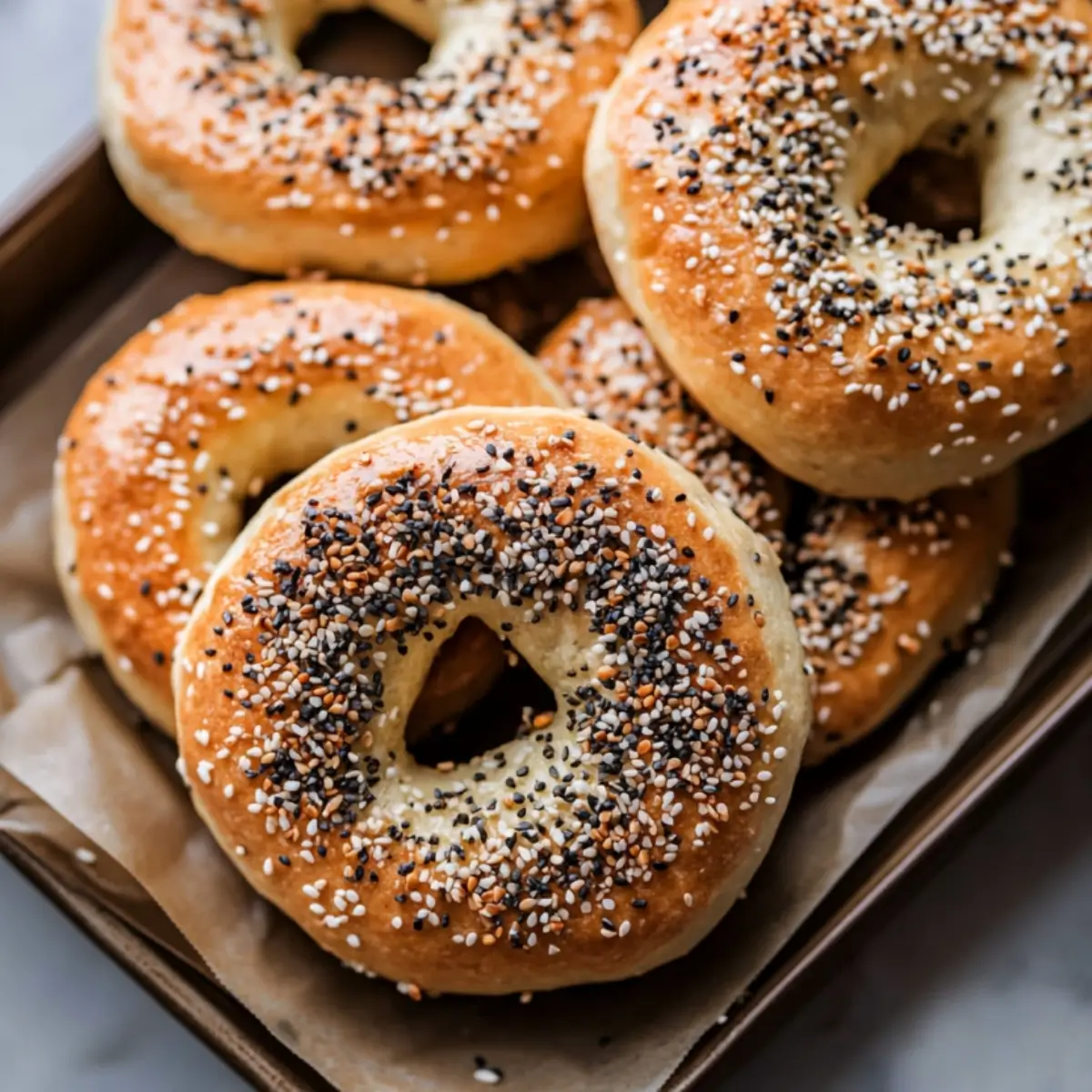 High protein bagels with everything seasoning on a parchment paper cooling rack